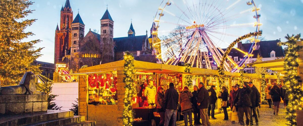 Christmas market in Vrijthof square, historical old town, with ice skating rink and ferris wheel, Servatius Basilica Church